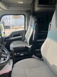 Kenworth T680 cabin interior showing driver seat and passenger seat in view with overhead storage and window