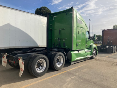Kenworth T680 tractor-trailer in green full side view showing sleeper cab and rear wheels.