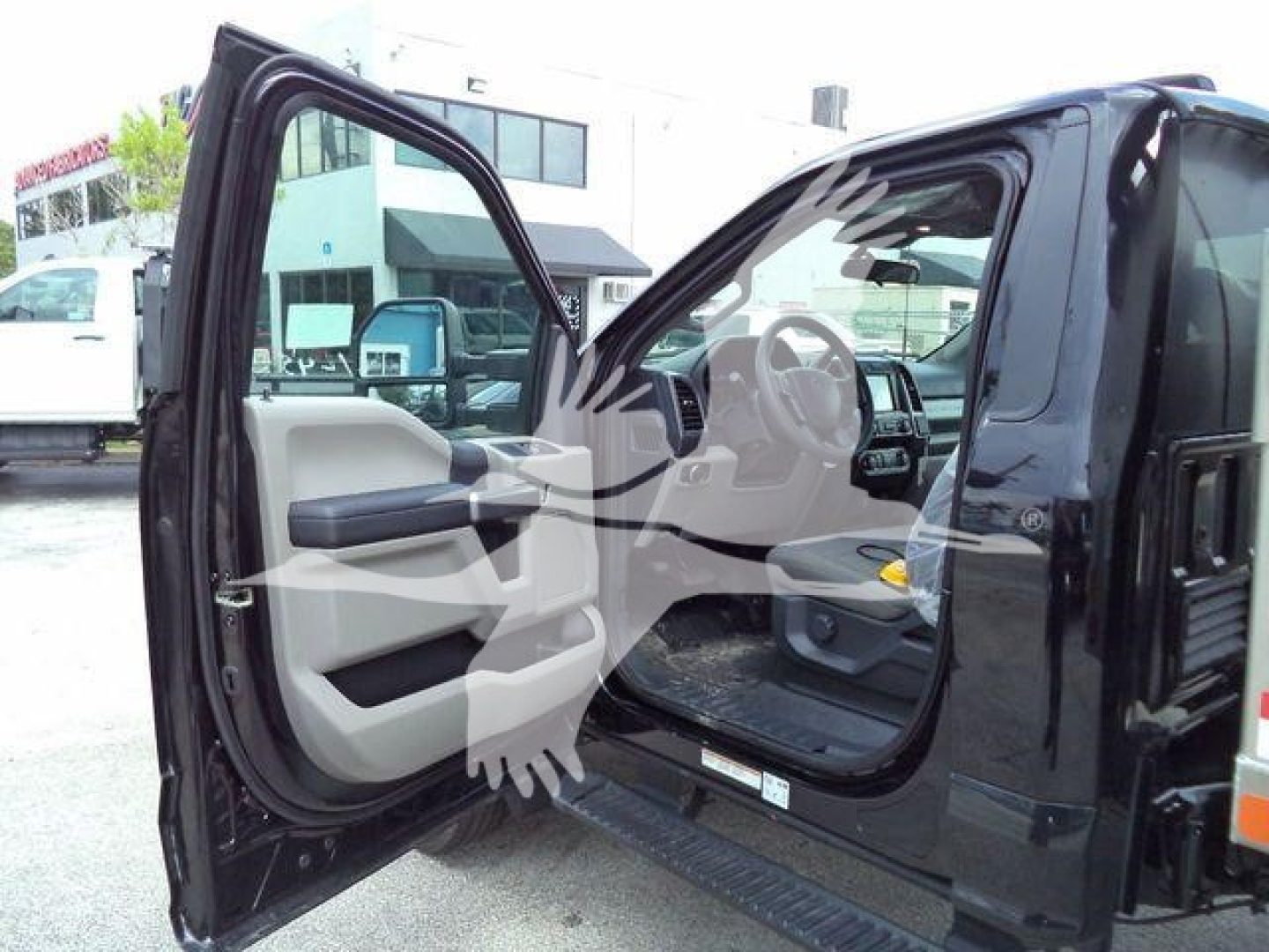 Ford F-550 cab interior and open driver door showing steering wheel and dashboard in a black truck.
