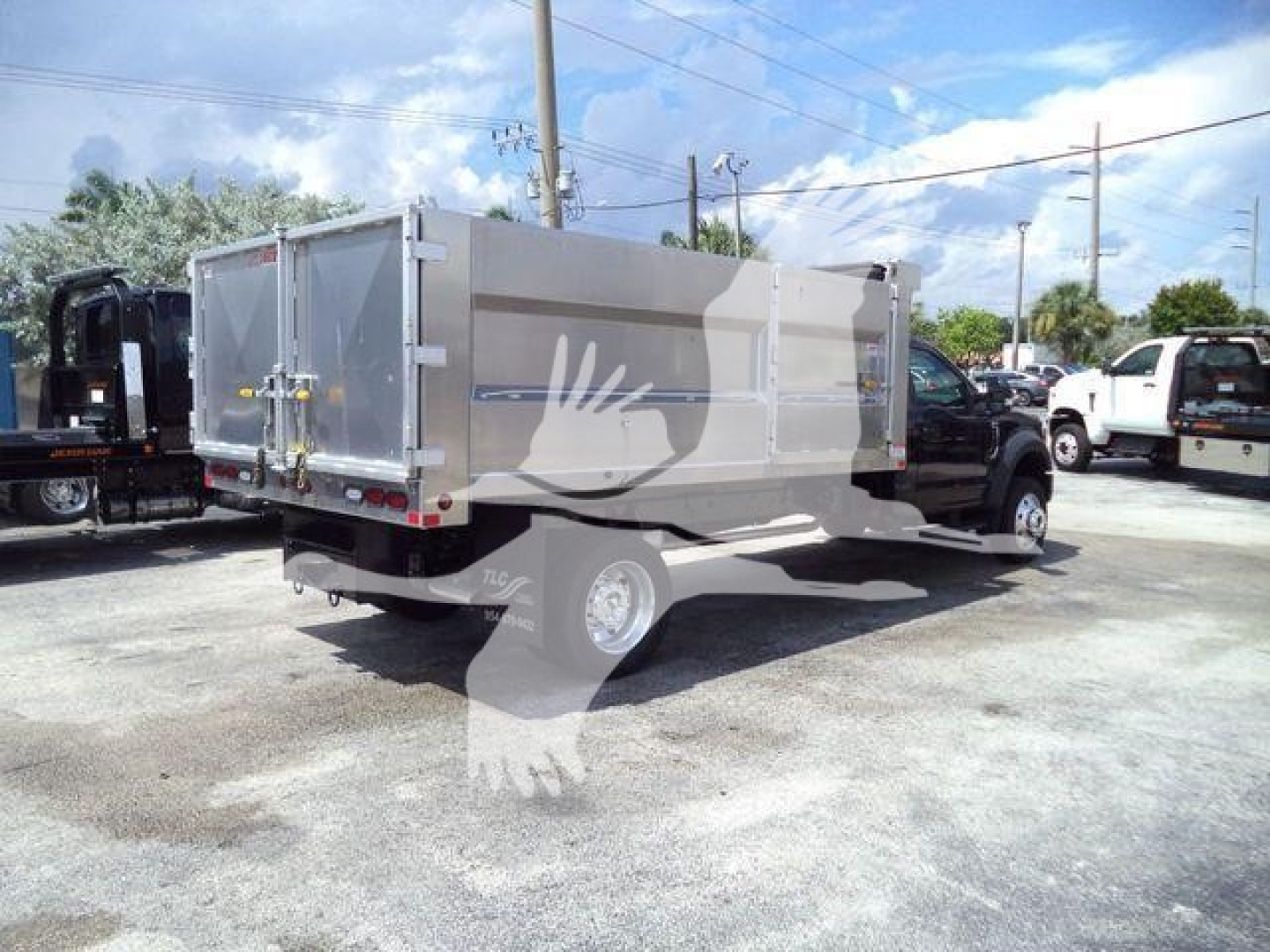 Ford F-550 dump bed rear three-quarter view showing aluminum dump bed and dual rear wheels.