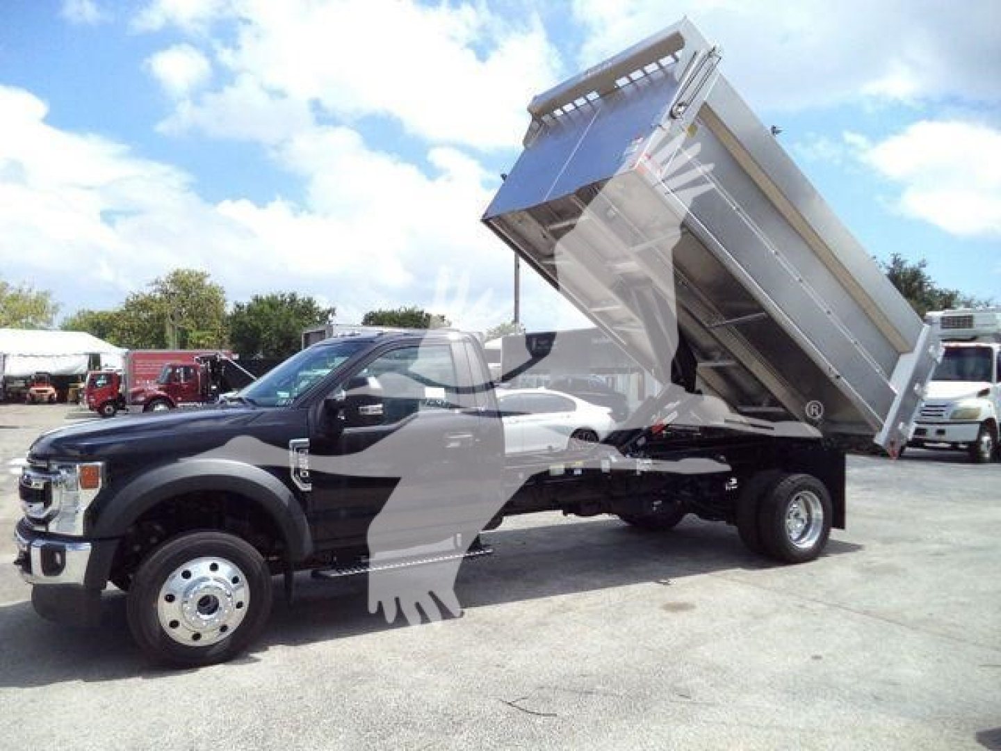 Ford F-550 dump truck with raised bed showing hydraulic mechanism and aluminum dump body.