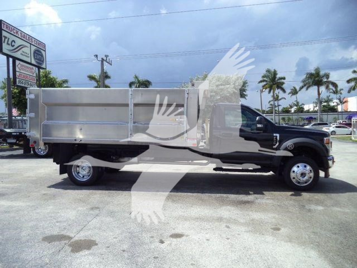 2022 Ford F-550 dump truck side profile showing aluminum dump bed and crew cab, stock number F5504X4ALUMDMP, black cab with chrome wheels.