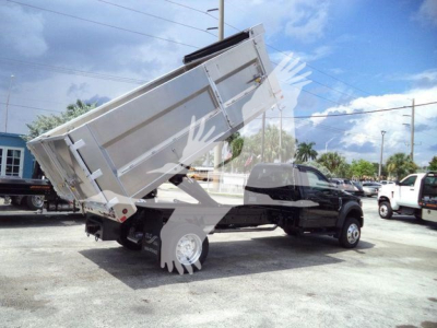 Ford F-550 dump bed truck angled rear view with raised aluminum dump body and dual rear wheels.