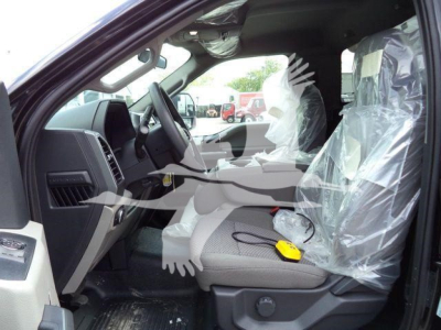 Ford F-550 interior driver seat area with plastic protective covers and wiring tester on seat.