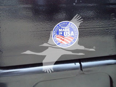 Sticker reading 'MADE IN USA' with eagle logo on a black surface, near a seam and a step/trim along the vehicle.