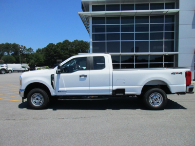 Ford F-250 Super Duty pickup truck side view in white with extended cab and long bed, dealership lot, 2WD, badge visible.