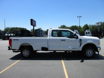 Ford F-250 Super Duty pickup truck side view showing extended cab and white paint in a dealership lot.
