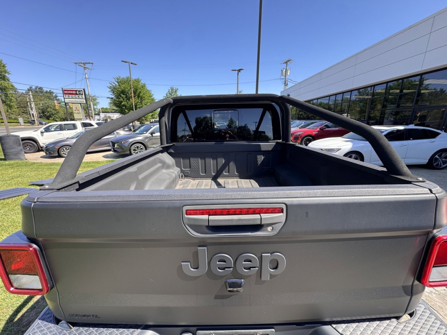 Jeep Gladiator tailgate with Jeep logo and rear view showing truck bed and roll bar.
