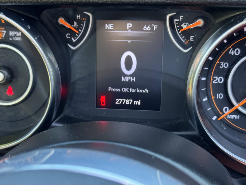 Jeep Gladiator instrument cluster showing 0 MPH on digital display, with gear indicator in P, compass NE, exterior temperature 66°F, odometer 27787 mi, surrounded by speedometer and tachometer dials.