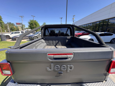 Jeep Gladiator tailgate with Jeep logo and rear view showing truck bed and roll bar.