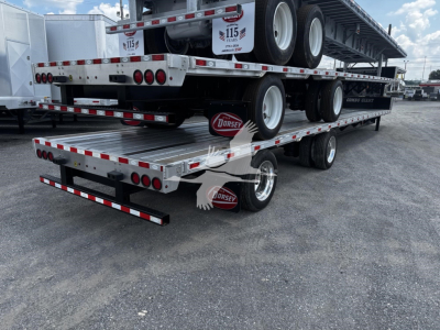 Flatbed trailer stack showing multiple Dorsey trailers and wheels, with red-and-white reflective tape and Dorsey logo on mudflaps.