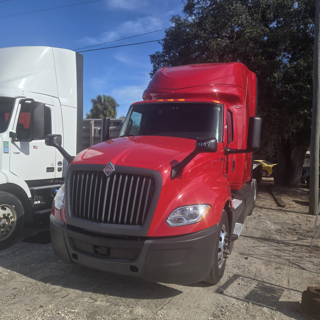 Truck cab front view of a red 2020 International LT625 midroof tractor showing grille, headlights, and aerodynamic mirrors.