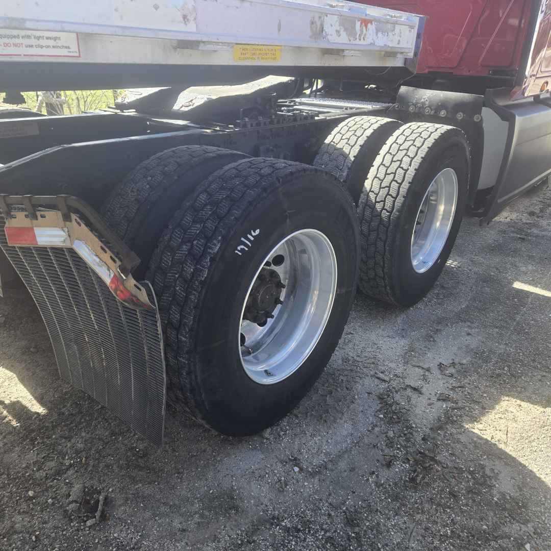 Triple rear axle setup on a 2020 International LT625 midrooft truck showing dual rear tires and mudflaps.