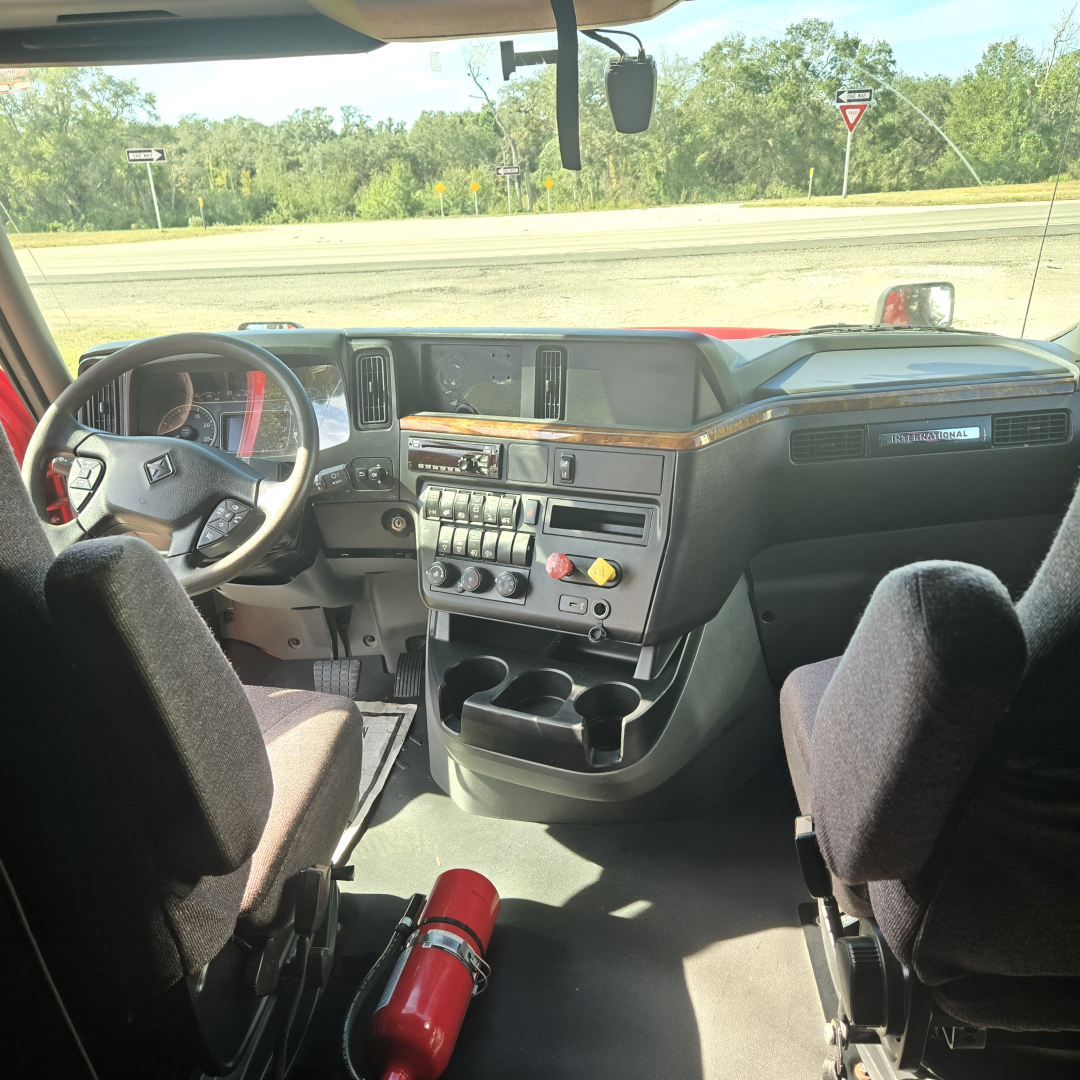 Interior of a 2020 International LT625 midroof tractor cab showing steering wheel, dashboard with controls, and center console.