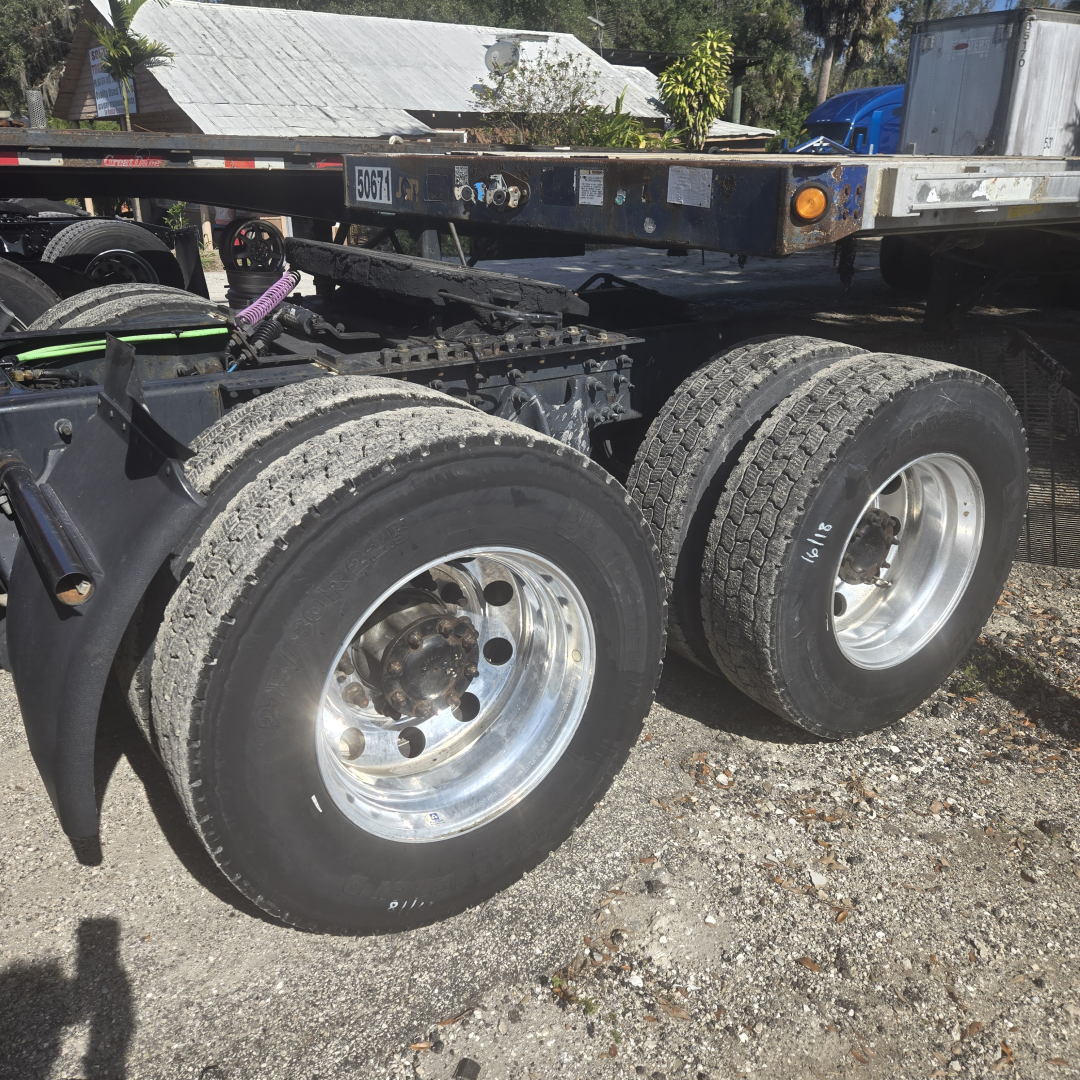 Truck rear axles and wheels of a 2020 International LT625MIDROOF chassis showing dual rear tires and frame rails.