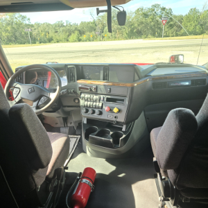 Interior of a 2020 International LT625 midroof tractor cab showing steering wheel, dashboard with controls, and center console.