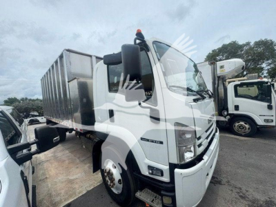 Isuzu flatbed truck cab view showing front grille and side mirror with label area on door