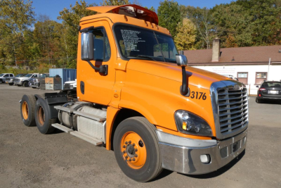 Freightliner Cascadia 125 truck cab in orange, side view showing front grille, wheel, and cab door with numbers 3176.