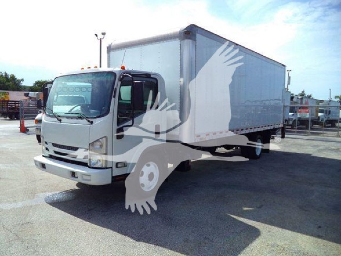 Isuzu NPR/NRR box truck with white cab and cargo box visible, highway scene, faint overlay watermark of a bird logo