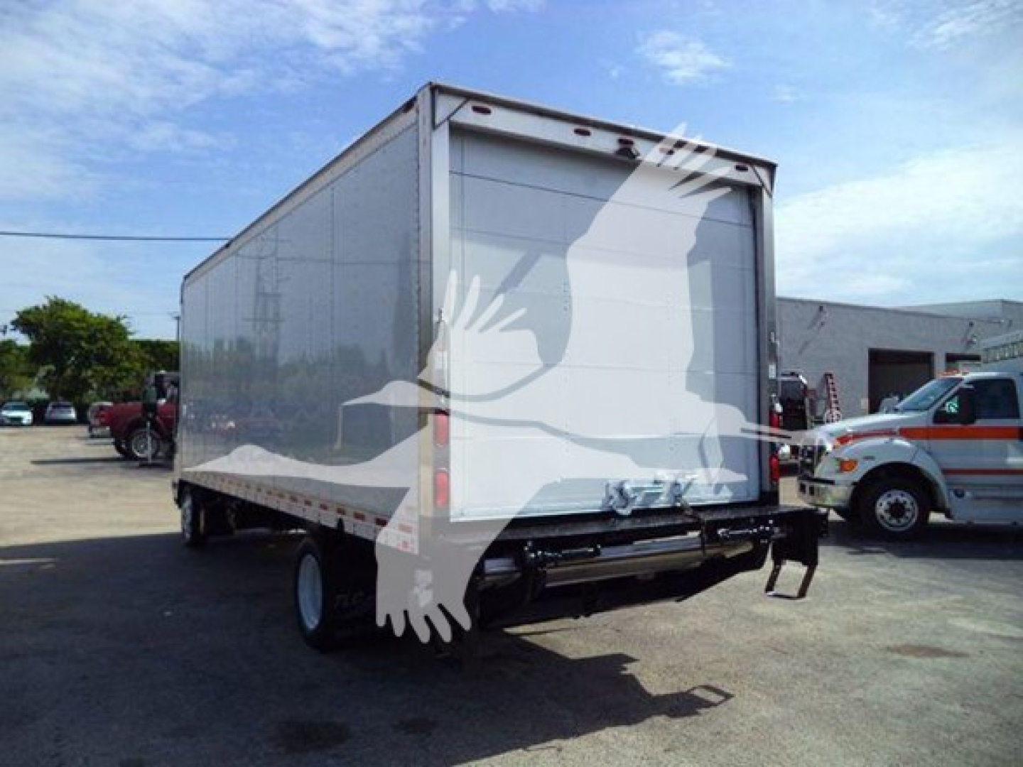 Isuzu NRR box truck rear view showing back doors and cargo area, with hitch and rear bumper visible.