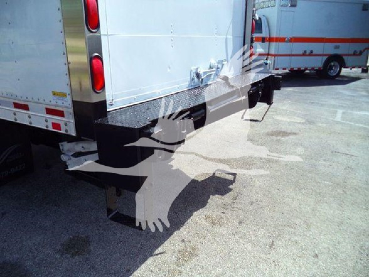 Isuzu NRR box truck rear view showing bumper, taillights, and rear underride guard with attached step and reflective surfaces.