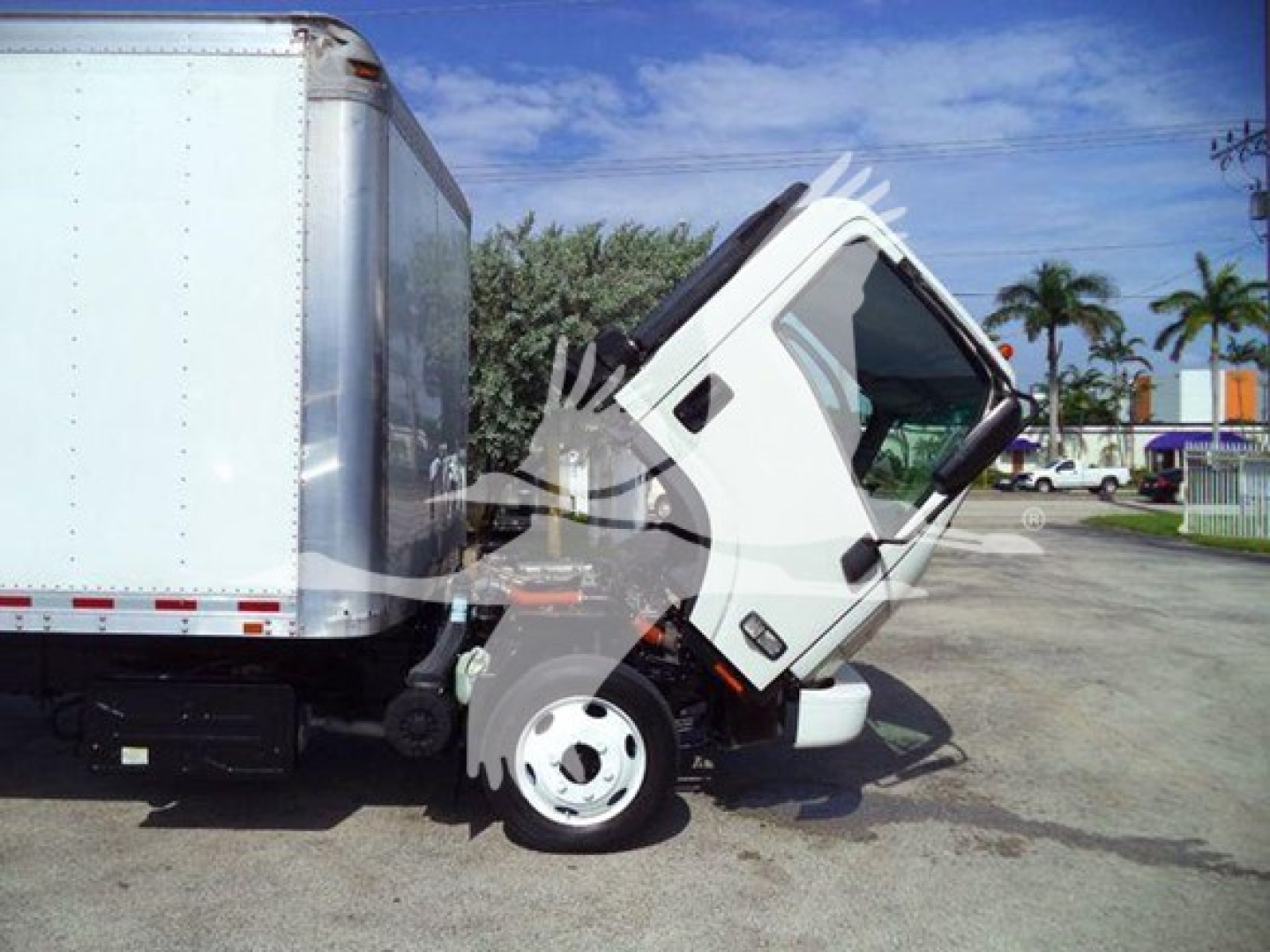 Isuzu NRR box truck cab tilted upward for inspection; side view shows front wheel and cargo box.