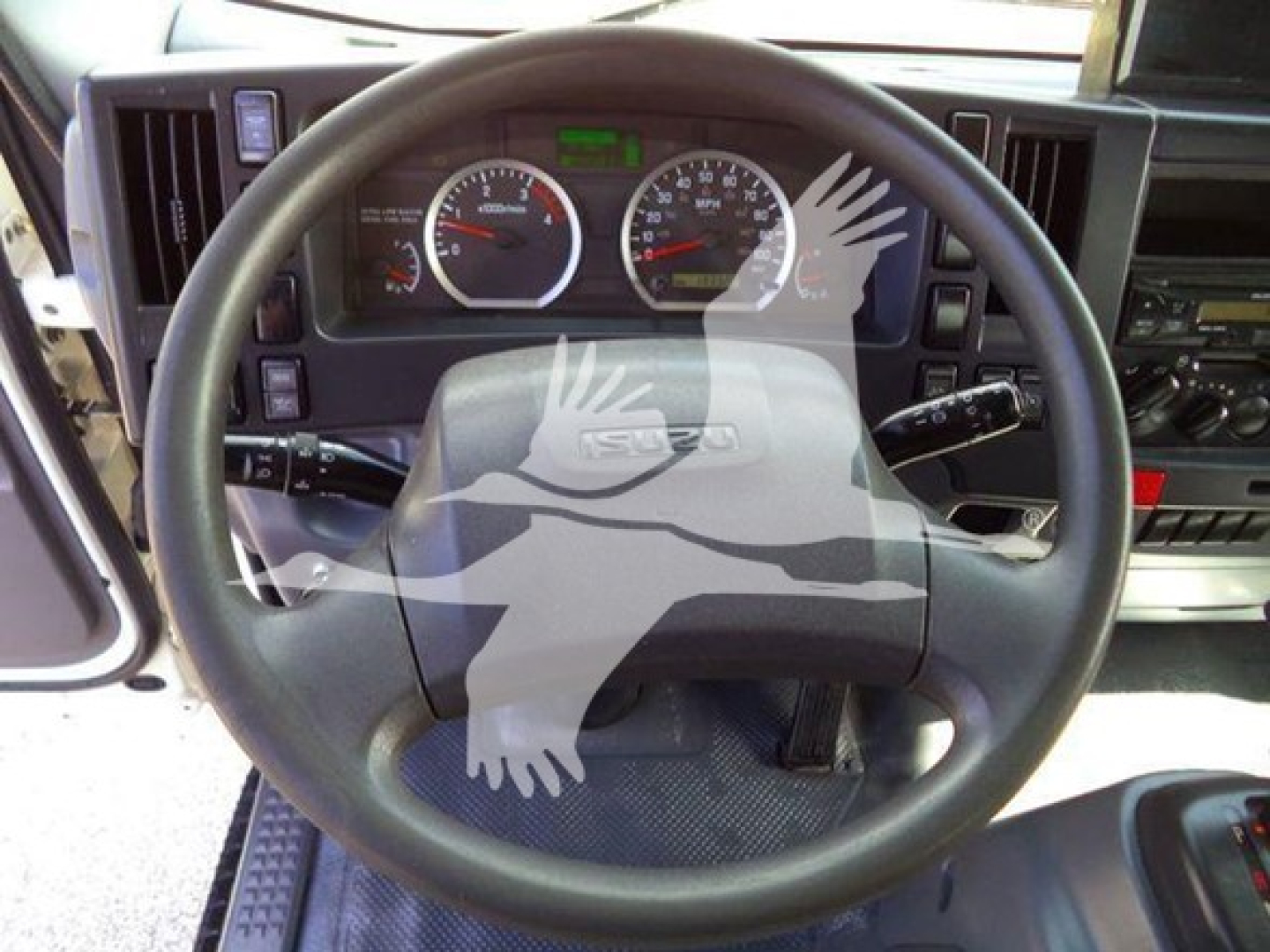 dashboard and steering wheel of a Isuzu NRR with gauge cluster and steering controls visible.