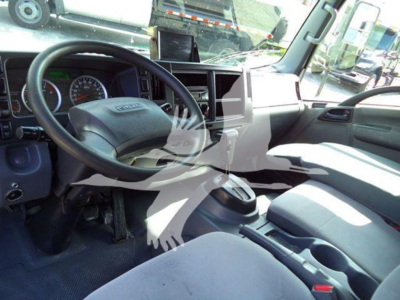 Isuzu NRR truck cab interior showing steering wheel, dashboard, center console, and gear lever.