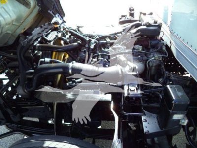 Isuzu NRR engine bay view with multiple hoses and components visible; no legible text or labels clearly readable.