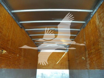 Inside cargo box of a truck showing wooden walls and metal ceiling ribs