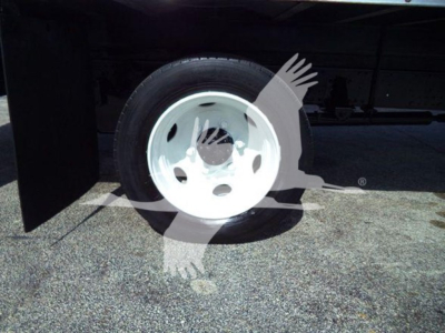 Isuzu NRR truck wheel and fender area showing a white steel wheel on a box truck chassis.