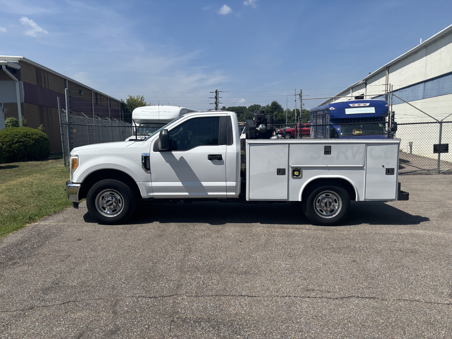 2017 Ford F250 Cab and Chassis utility truck side view showing service body with multiple compartments and storage boxes.