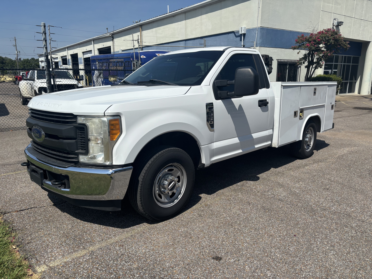 Ford F-250 cab and chassis utility truck in white, side view, with utility bed and compartments.