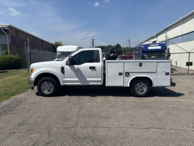 2017 Ford F250 Cab and Chassis utility truck side view showing service body with multiple compartments and storage boxes.