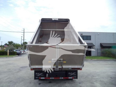 Isuzu NPR-HD dump truck bed showing open cargo area and rear bumper with TLC branding.