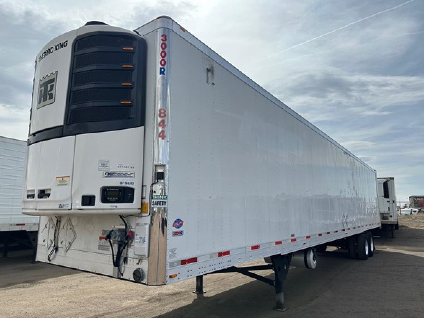 Utility 3000R trailer with reefer unit at the front, white exterior, side door, loading lights, and landing gear visible.