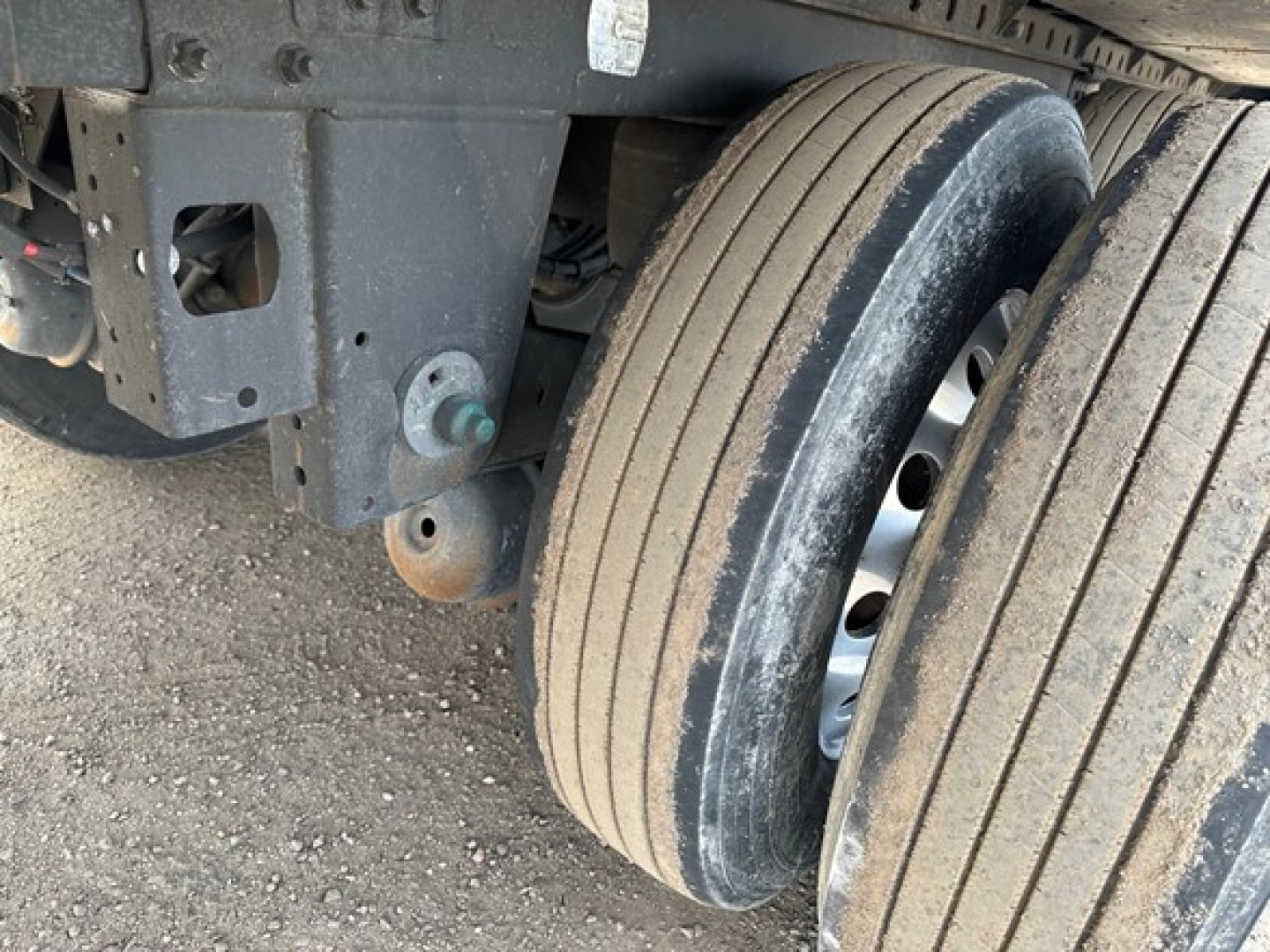 Reefer trailer undercarriage showing tandem axle dual wheels and suspension components with visible tires and frame.