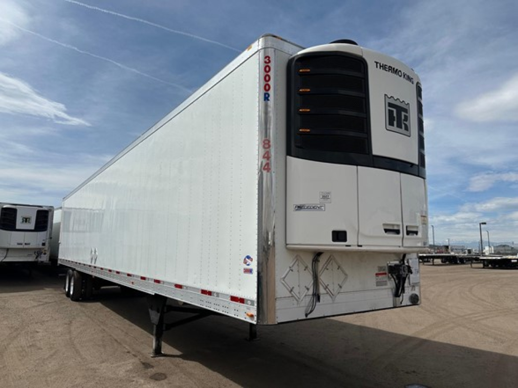 Utility 3000R refrigerated trailer showing Thermo King unit and side of reefer trailer with VIN and stock number in yard.