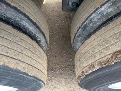 Two trailer axles with dual tires showing tread and dirt, part of a Utility 3000R trailer.