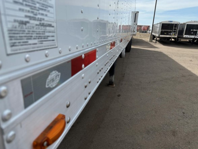 Trailer side of a 2022 Utility 3000R reefer trailer showing riveted aluminum body, reflectors, and small inspection sticker along the lower rail.