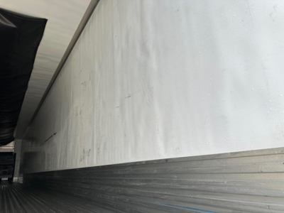Trailer side view showing aluminum Reefer body with lower ribbed paneling and smooth upper wall.