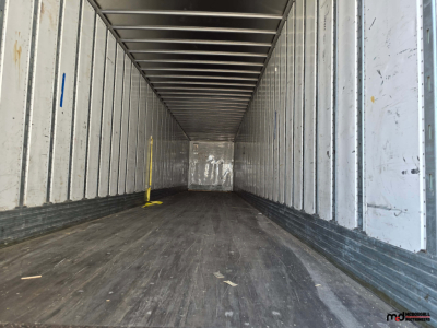 Trailer interior showing empty cargo space of a 53' dry van trailer with metal wall ribs and wooden floor.