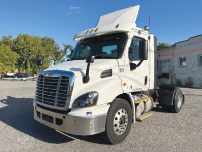 Truck cab showing a white 2017 Freightliner Cascadia 113 daycab with raised hood, chrome grille, dual mirrors, and front bumper; VIN plate not visible.
