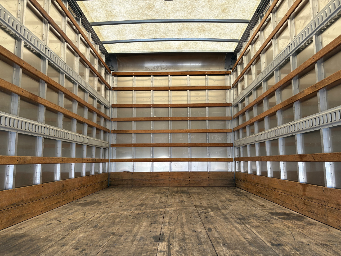 Isuzu NPR-HD truck box interior showing wooden side rails and empty cargo area.