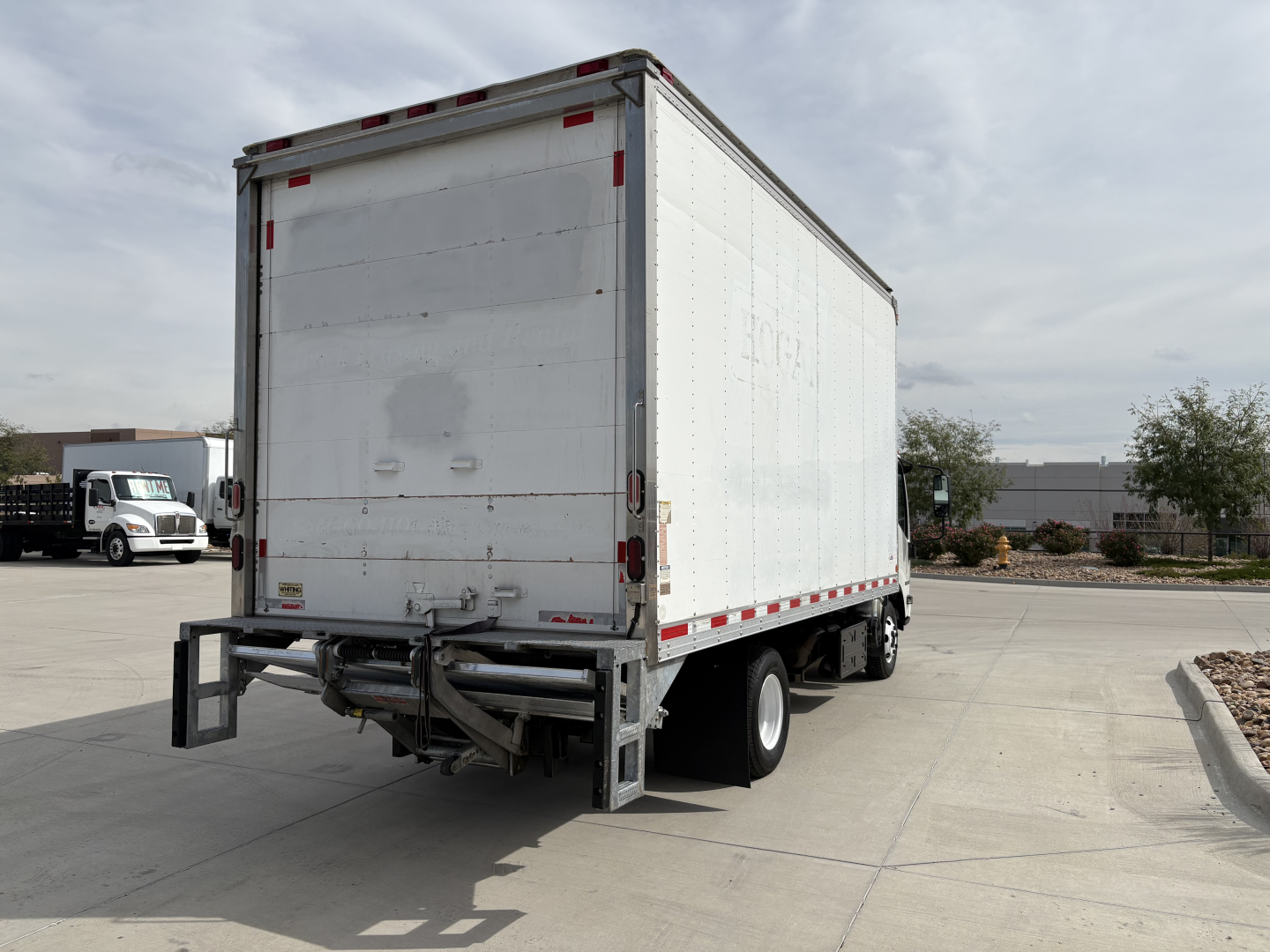 Isuzu NPR-HD box truck rear view showing blank white cargo box with bumper and wheels, no visible labels or text.