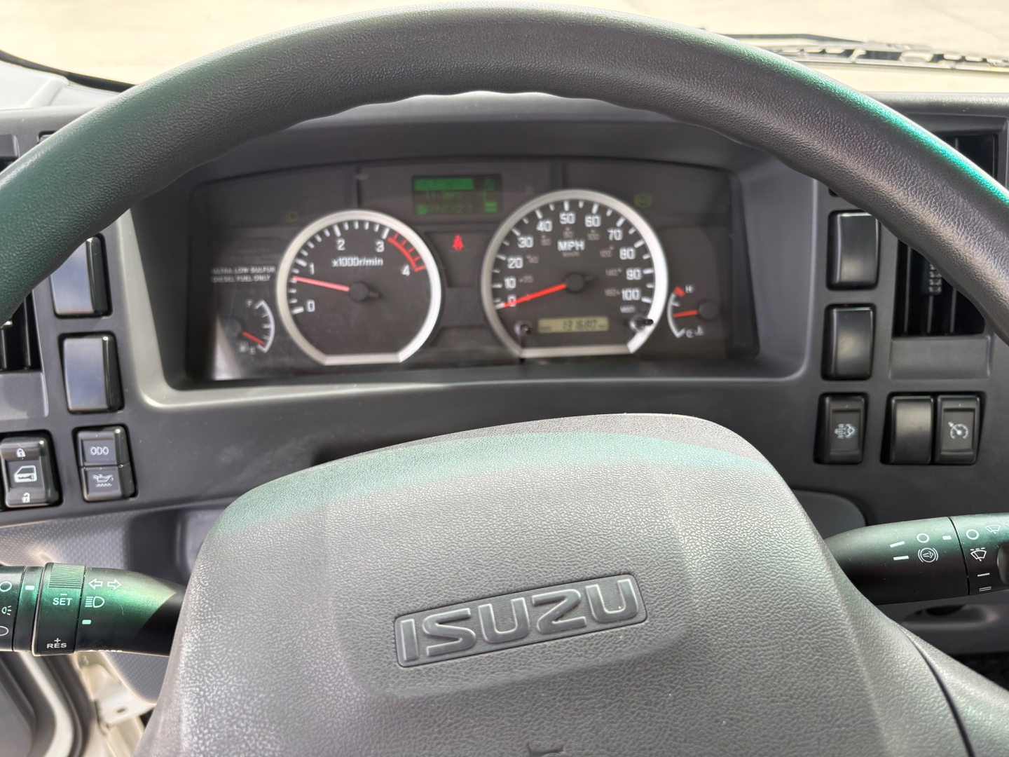 Isuzu NPR-HD truck dashboard and steering wheel showing instrument cluster and steering column.