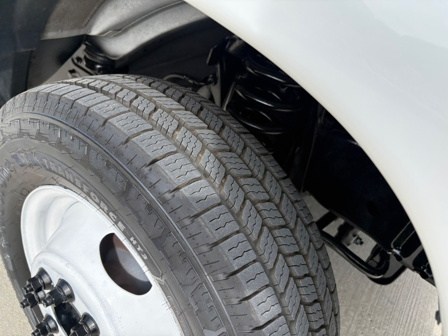 Isuzu NPR-HD wheel and front fender showing tire tread and part of suspension.