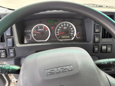 Isuzu NPR-HD truck dashboard and steering wheel showing instrument cluster and steering column.