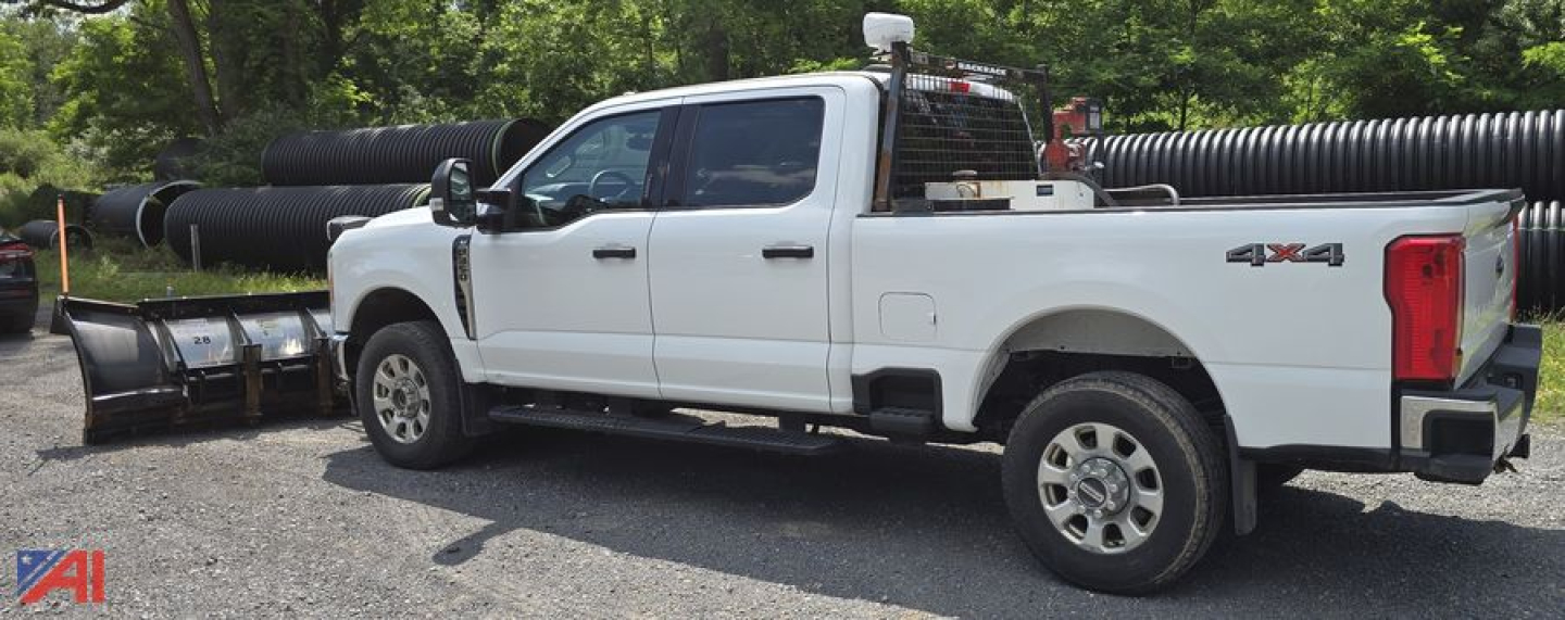 Ford F-350 Super Duty XLT Crew Cab 4x4 with plow attachment in a gravel lot.