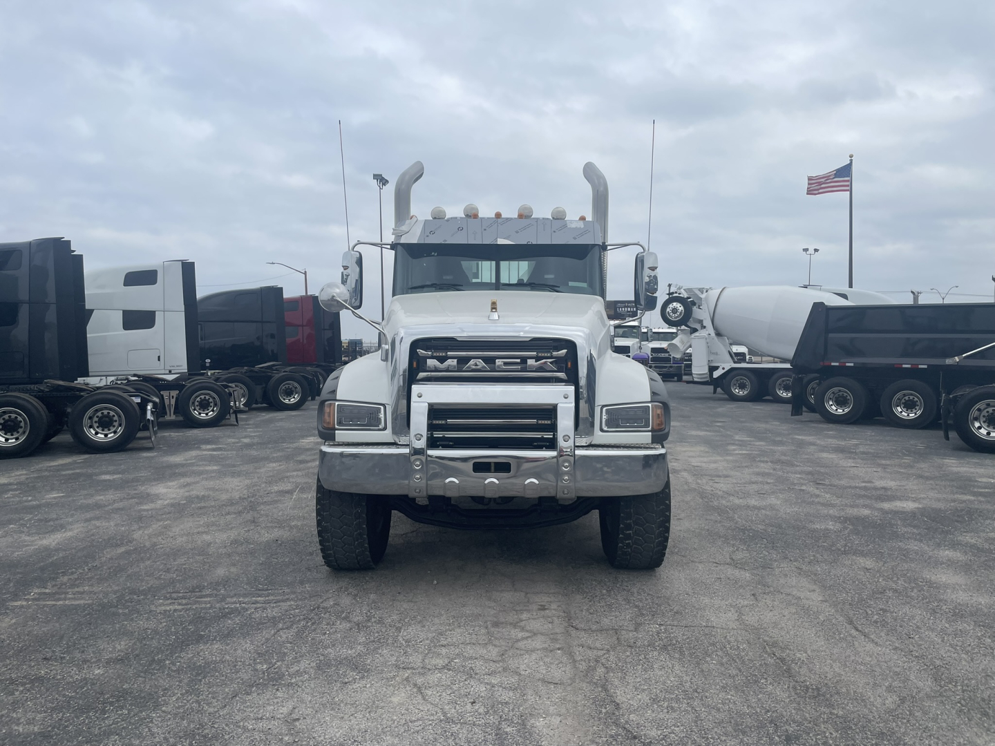 Mack GR84FT truck front view showing chrome grille and bumper in a dealer lot.